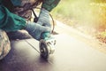 Close-up of worker cutting stone with grinder. Dust while grinding stone pavement. Toned. Royalty Free Stock Photo