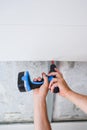Close-up of a worker fastening a suspended ceiling panel with a screwdriver Royalty Free Stock Photo