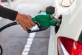 close up worker hand holding nozzle fuel fill oil into car tank at pump gas station Royalty Free Stock Photo