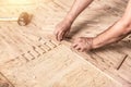 Close up of worker installing wood parquet. Carpenter on work putting wood parquet pieces Royalty Free Stock Photo