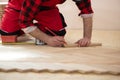 Close up of worker installing wood parquet. Worker laying parquet flooring. Worker installing wooden laminate flooring Royalty Free Stock Photo