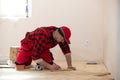 Close up of worker installing wood parquet. Worker laying parquet flooring. Worker installing wooden laminate flooring Royalty Free Stock Photo