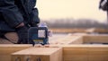 Close up of worker leveling wooden beam on construction site on bright cloudy sky background. Clip. Male builders making