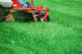 Close up on worker mowing the lawn
