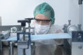 Close up of worker producing surgical mask in modern factory, Covid-19 protection and medical concept
