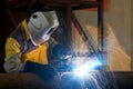 Close up of worker with protective mask welding metal