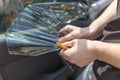 Close up of worker pulling off sun protection tinted foil from side car window Royalty Free Stock Photo