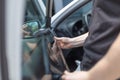 Close up of worker pulling off sun protection tinted foil from side car window Royalty Free Stock Photo