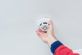 Close up worker`s hand installing fire alarm on the ceiling Royalty Free Stock Photo