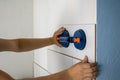 Close-up of man tiler hands installing ceramic tiles on walls of future bathroom or kitchen. Tiles installation, home improvement, Royalty Free Stock Photo