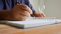 Close up worker using right hand recording the good idea and  left hand holding light bulb Royalty Free Stock Photo