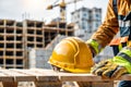 Close-up of worker wearing safety helmet and holding blueprint on construction site