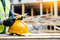 Close-up of worker wearing safety helmet and holding blueprint on construction site Royalty Free Stock Photo