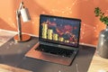 Close up of workplace with laptop, lamp and falling golden coins stack on bright wall background. Gold price concept.