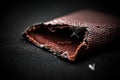 Close-up of worn brown leather wallet with cobweb on black background Royalty Free Stock Photo