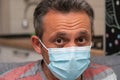 Close-up of worried man with sick eyes wearing surgical mask