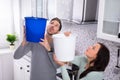 Couple Collecting Water Leaking From Ceiling In Bucket Royalty Free Stock Photo