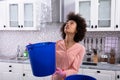 Woman Collecting Water Leaking From Ceiling In Bucket Royalty Free Stock Photo