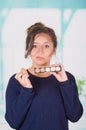 Close up of worried young woman holding a make up palette and doing crazy make-up in her face using a sponge, in a