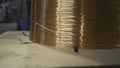 Close-up of wound copper wire in production. Creative. Thin line of wire on industrial coil. Production of copper wire Royalty Free Stock Photo