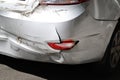 Close-up wrecked rear bumper and tail lights of new modern grey car after vehicle accident on road at bright sunny day Royalty Free Stock Photo