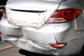 Close-up wrecked rear bumper and tail lights of new modern grey car after vehicle accident on road at bright sunny day Royalty Free Stock Photo