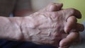 Close-up of the wrinkled sinewy hands of an elderly man meditating. The pensioner crossed his palms. Selective focus. macro