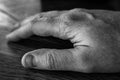 Mans hand resting on table in black and white