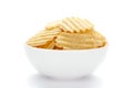 Close up of Wrinkled Wavy Potato Chips in white ceramic bowl, Popular Ready to eat crunchy, salty pale-yellow color over white Royalty Free Stock Photo