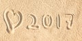 Close up on 2017 written in the sand of a beach