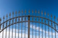 Wrought Iron Gate with Sharp Points on Blue Sky with Clouds Royalty Free Stock Photo