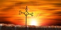 Wrought Iron Religious Cross on a Beautiful Sunset Sky with Sunbeams Royalty Free Stock Photo
