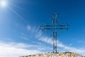 Wrought Iron Religious Cross Against a Clear Blue Sky with Clouds Royalty Free Stock Photo