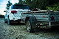 Close up 4x4 off road car vehicle standing on the sandy surface in beach with trailer d Royalty Free Stock Photo