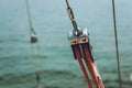 Close up of yacht equipment. Part of yacht with red ropes and capstan. Sailing boat pulley with nautical rope. Marine background Royalty Free Stock Photo