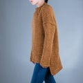 Close up of yang woman. Brown sweater and blue jeans. People concept.