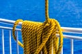 Yellow braided rope draped over a ship railing Royalty Free Stock Photo