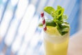 Close-up Yellow Cocktail with soda bubble topping with mint leaves and slice of lime with red and with strip straw