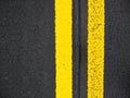Close-up yellow dividing lines on the road with copy space. Yellow double solid line. Road markings on asphalt. Gray asphalt Royalty Free Stock Photo