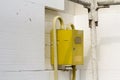 Close-up of yellow gas meter box with connecting pipes hanging o Royalty Free Stock Photo