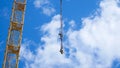 Close up of a yellow and green crane boom with main block and jib against a clear blue sky. Tower building cranes Royalty Free Stock Photo