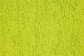 Close up of a yellow-green dragged plaster wall.