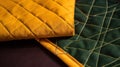 a close up of a yellow and green quilt on a bed sheet with a pillow on top of the quilted bed sheet and the quilt is folded over