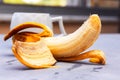 Close up of yellow half peeled banana on gray surface background. Fresh organic fruit. Healthy eating concept. Selective focus. Royalty Free Stock Photo