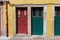 Close up of yellow house facade with red and green entrance doors in old town of Porto, Portugal.