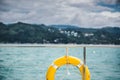 Close-up Yellow life ring hanging on boat with ocean background. Royalty Free Stock Photo