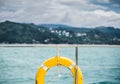 Close-up Yellow life ring hanging on boat with ocean background. Royalty Free Stock Photo