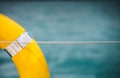 Close-up Yellow life ring hanging on boat with ocean background. Royalty Free Stock Photo