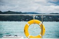 Close-up Yellow life ring hanging on boat with ocean background. Royalty Free Stock Photo