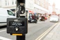 Close up of yellow metal crosswalk button for pedestrian crossing signal in London, UK for traffic rules. Classic pedestrian cross Royalty Free Stock Photo